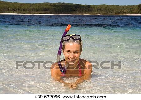 Stock Photograph - Woman lying in a beautiful lake, wearing a snorkel. Fraser Island, Australia. Fotosearch