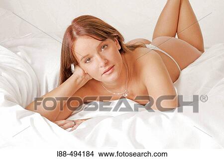 Woman lying in bed. View Large Photo Image Picture - Woman lying in bed.. Fotosearch