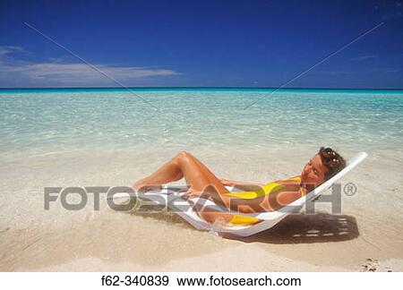 Stock Photo - Woman lying in chair on beach. Varadero. Cuba. Fotosearch