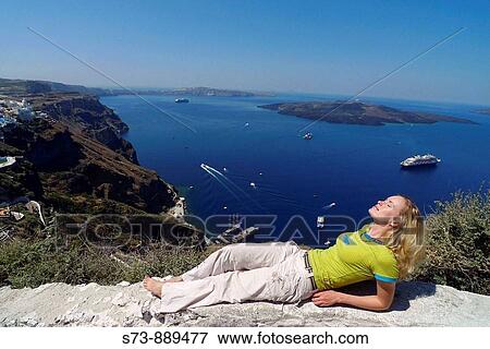 Stock Photo - Woman lying in Santorini, Fira, Cyclades Islands, Greece. Fotosearch
