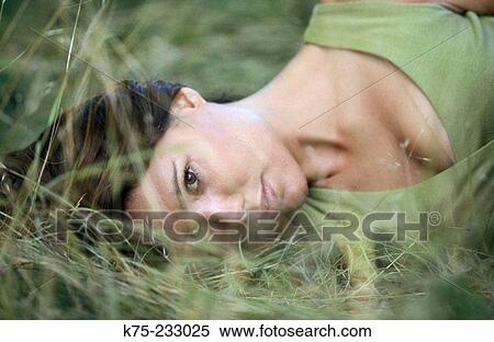Stock Photography - Woman lying in the grass. Fotosearch