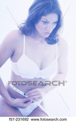 Woman measures her waist View Large Photo Image Stock Image - Woman measures her waist. Fotosearch