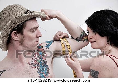 Woman measuring her husband's arm View Large Photo Image Stock Image - Woman measuring her husband's arm. Fotosearch