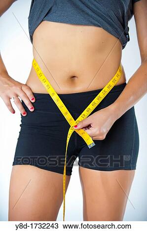 Woman measuring waistline Female 22, caucasian View Large Photo Image Stock Image - Woman measuring waistline Female 22, caucasian. Fotosearch
