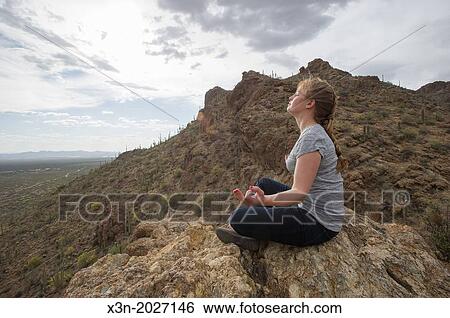 Stock Photograph - Woman meditating in desert, Tucson AZ.. Fotosearch