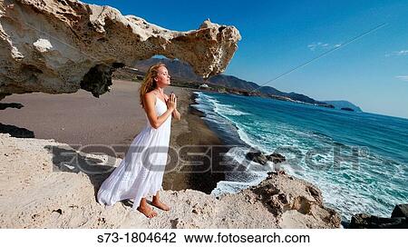 Woman meditating in Playa del Arco, Los Escullos Natural Reserve of Cabo de Gata-N? jar, Almer? a province View Large Photo Image Stock Image - Woman meditating in Playa del Arco, Los Escullos Natural Reserve of Cabo de Gata-N? jar, Almer? a province. Fotosearch