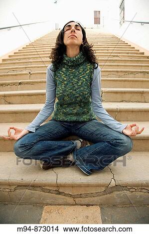 Picture - Woman meditating in stairs. Fotosearch