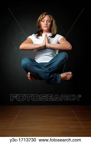 Woman meditating while floating in air View Large Photo Image Stock Image - Woman meditating while floating in air. Fotosearch