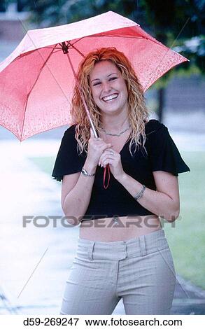 Woman mid 20's smiling, umbrella in the rain View Large Photo Image Stock Photo - Woman mid 20's smiling, umbrella in the rain. Fotosearch