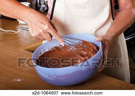 Woman mixing chocolate cake ingredients in a mixing bowl with a whisk View Large Photo Image Stock Photo - Woman mixing chocolate cake ingredients in a mixing bowl with a whisk. Fotosearch