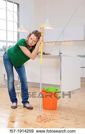 Stock Photo - Woman mopping her kitchen floor. Fotosearch