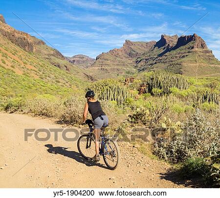Woman mountain biking in area known locally as Grand Canyon on Gran Canaria, Canary Islands, Spain View Large Photo Image Stock Image - Woman mountain biking in area known locally as Grand Canyon on Gran Canaria, Canary Islands, Spain. Fotosearch