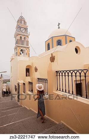 Stock Photo - Woman near the Catholic Church of the Sanctus Ioannes Baptista in Fira, Santorini, Cyclades Islands, Greek Islands, Greece, Europe.. Fotosearch