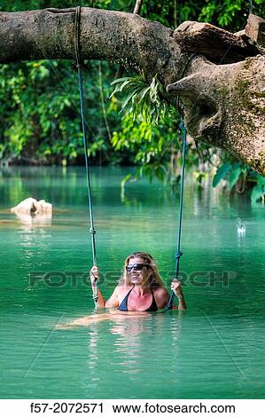 Woman on a swing in the Blue Lagoon in Vang Vieng, Laos. View Large Photo Image Stock Image - Woman on a swing in the Blue Lagoon in Vang Vieng, Laos.. Fotosearch