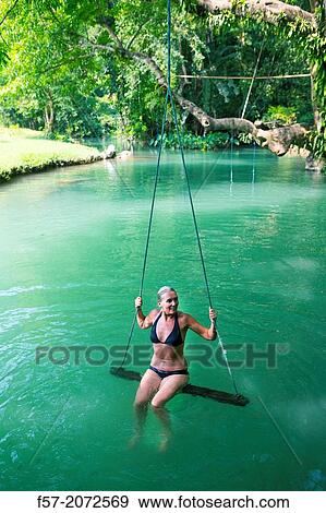 Woman on a swing in the Blue Lagoon in Vang Vieng, Laos. View Large Photo Image Stock Photo - Woman on a swing in the Blue Lagoon in Vang Vieng, Laos.. Fotosearch