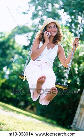 woman on a swing with cellular View Large Photo Image Picture - woman on a swing with cellular. Fotosearch