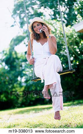 woman on a swing with cellular View Large Photo Image Stock Image - woman on a swing with cellular. Fotosearch