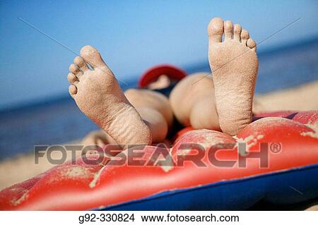 Picture - Woman on air mattress on beach. Sk? ne. Sweden. Fotosearch