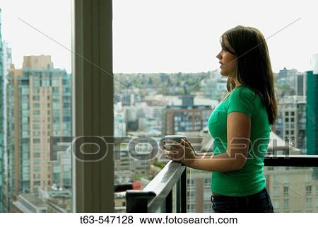 Woman on balcony drinking coffee looking out. Vancouver. BC. Canada. View Large Photo Image Stock Photo - Woman on balcony drinking coffee looking out. Vancouver. BC. Canada.. Fotosearch