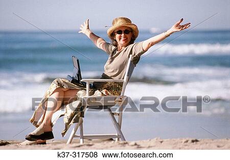 Woman on beach using her laptop computer View Large Photo Image Stock Photo - Woman on beach using her laptop computer. Fotosearch