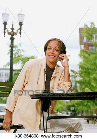 Woman on cell phone in outdoor urban setting. View Large Photo Image Stock Photo - Woman on cell phone in outdoor urban setting.. Fotosearch