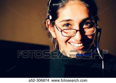 Picture - Woman on computer with headphones. Fotosearch