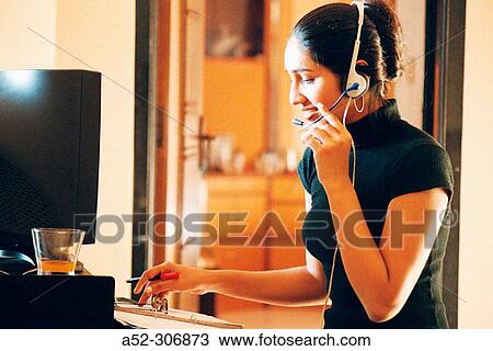 Woman on computer with headphones View Large Photo Image Stock Image - Woman on computer with headphones. Fotosearch