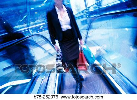 Stock Photograph - Woman on escalator. Fotosearch