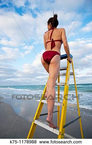 Woman on ladder at the beach View Large Photo Image Stock Photo - Woman on ladder at the beach. Fotosearch