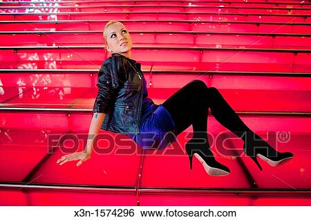 Stock Photograph - Woman on red steps, Times Square New York. Fotosearch