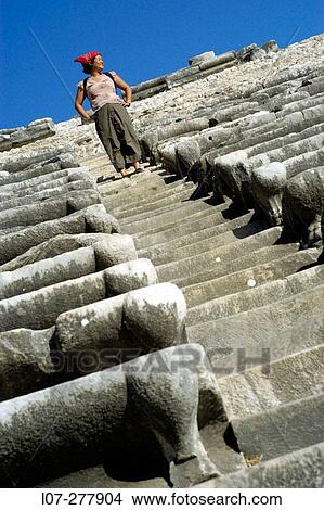 Picture - Woman on steps of the ancient theatre, ruins of Miletus. Turkey. Fotosearch