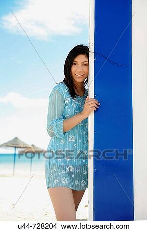 Picture - Woman on the beach blue house. Fotosearch