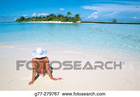 Stock Photo - Woman on the beach in White Sands Resort and Spa. Ari Atoll. Maldives. Fotosearch