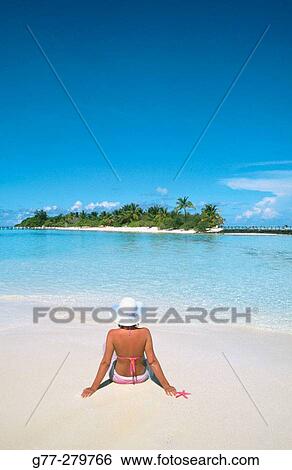 Stock Photograph - Woman on the beach in White Sands Resort and Spa. Ari Atoll. Maldives. Fotosearch