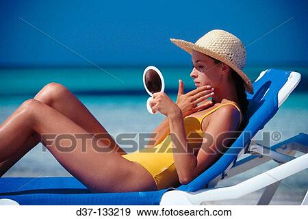 Woman on the beach, looking in a mirror View Large Photo Image Stock Photo - Woman on the beach, looking in a mirror. Fotosearch