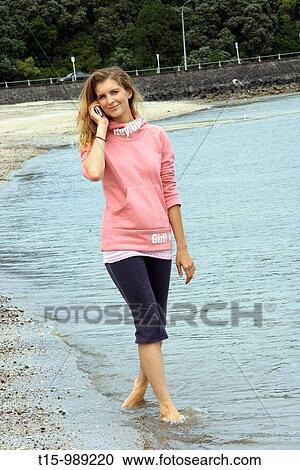 Woman on the beach talking on the phone View Large Photo Image Stock Image - Woman on the beach talking on the phone. Fotosearch