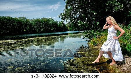 Picture - Woman on the pier in Lake Avral, Kirillovka, Samara Region, Russian Federation. Fotosearch