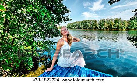 Woman on the pier in Lake Avral, Kirillovka, Samara Region, Russian Federation View Large Photo Image Picture - Woman on the pier in Lake Avral, Kirillovka, Samara Region, Russian Federation. Fotosearch