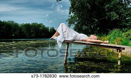 Woman on the pier in Lake Avral, Kirillovka, Samara Region, Russian Federation View Large Photo Image Stock Image - Woman on the pier in Lake Avral, Kirillovka, Samara Region, Russian Federation. Fotosearch