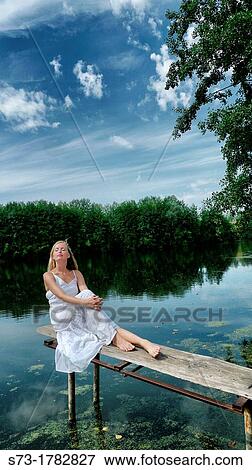 Stock Photo - Woman on the pier in Lake Avral, Kirillovka, Samara Region, Russian Federation. Fotosearch