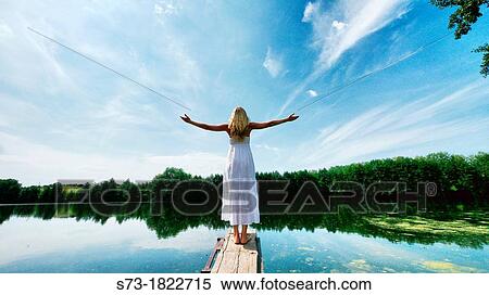 Stock Photography - Woman on the pier in Lake Avral, Kirillovka, Samara Region, Russian Federation. Fotosearch