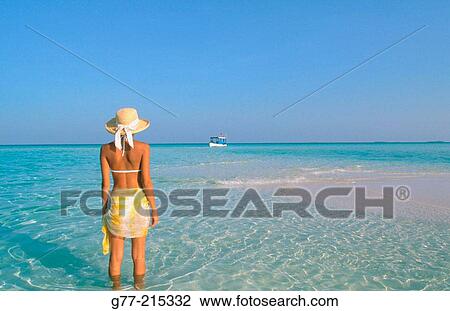 Stock Image - Woman on tropical beach. Maldives Islands. Fotosearch