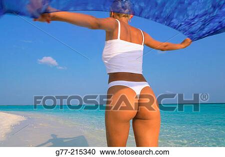 Stock Image - Woman on tropical beach. Maldives Islands. Fotosearch