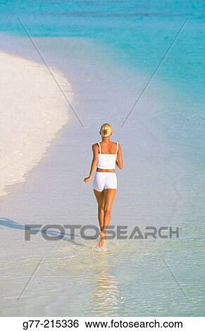 Stock Photograph - Woman on tropical beach. Maldives Islands. Fotosearch