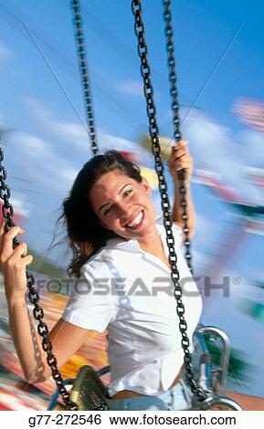 Stock Photograph - Woman on wave swinger carousel in amusement park. Florida. USA. Fotosearch