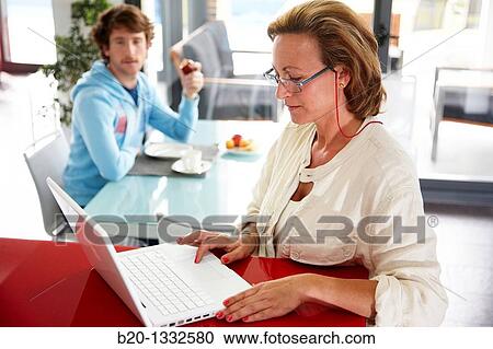 Woman online shopping with laptop computer and son having breakfast in kitchen View Large Photo Image Stock Image - Woman online shopping with laptop computer and son having breakfast in kitchen. Fotosearch