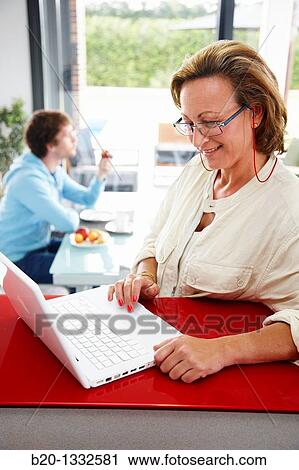 Woman online shopping with laptop computer and son having breakfast in kitchen View Large Photo Image Stock Image - Woman online shopping with laptop computer and son having breakfast in kitchen. Fotosearch