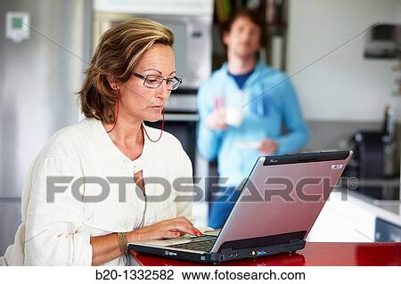 Woman online shopping with laptop computer and son having breakfast in kitchen View Large Photo Image Stock Image - Woman online shopping with laptop computer and son having breakfast in kitchen. Fotosearch