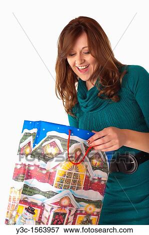 Woman opening Christmas shopping bag View Large Photo Image Stock Photo - Woman opening Christmas shopping bag. Fotosearch