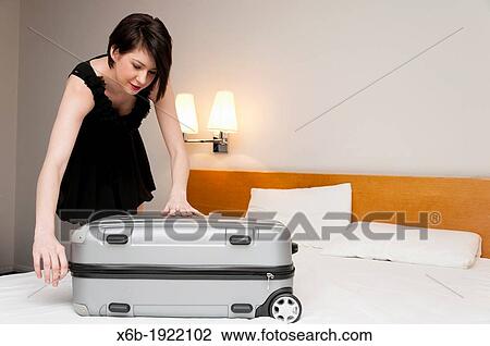 Woman packing suitcase in hotel room View Large Photo Image Stock Image - Woman packing suitcase in hotel room. Fotosearch